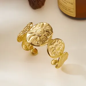 Dettaglio del bracciale rigido dorato in acciaio inox con rilievo a girasole.