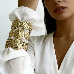 Set di 3 lussuosi bracciali rigidi dorati con trama a foglia indossati da una modella asiatica