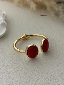 Detailed view of gold alloy bangle with two large oval red stones
