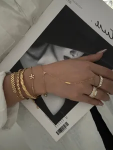 Detailed view of layered gold floral zircon bracelets and elegant hand chain sets