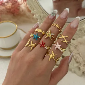 Elegantes Set aus vergoldeten Edelstahlringen mit Seestern und Muschel für den Urlaub
