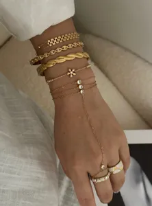 Detail view of gold-toned flower and zircon thin chain bracelets and hand chain