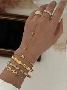 Detailed view of stacked gold bracelets including flower zircon fine chain and bangles
