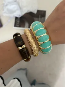 Detailansicht von bunten, breiten Stretch-Armbändern in Bonbonfarben am Handgelenk.
