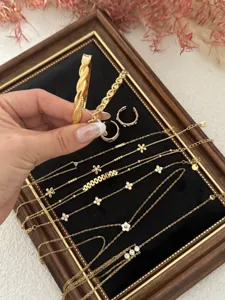 Detailed macro view of delicate gold flower and zircon charm bracelets on display