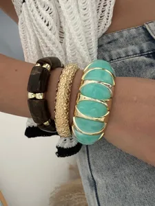 Detailansicht von leuchtenden, bonbonfarbenen, breiten, elastischen Armbändern am Handgelenk