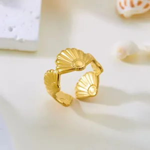 Makroansicht eines vergoldeten Edelstahlrings mit Muscheldesign und verstellbarem Band