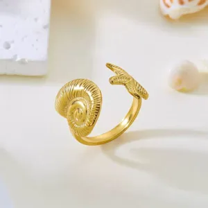 Detail eines vergoldeten Edelstahlrings mit Seestern- und Muscheldesign im Freien