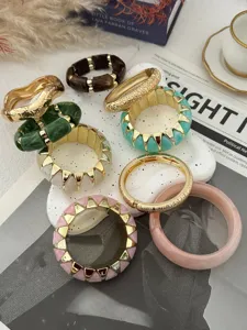 Set aus bonbonfarbenen elastischen Armbändern und breiten Harzreifen in stilvollem Design.