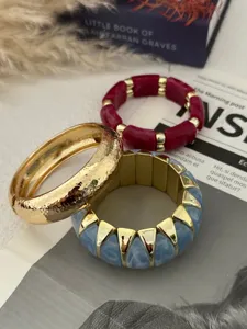 Detailansicht bunter Bonbon-Stretch-Armbänder und goldener strukturierter Armreif.