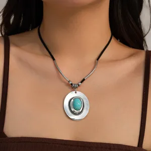 Detail of vintage turquoise hat pendant necklace with black velvet cord on model