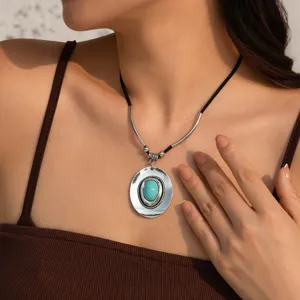 Detail of bohemian turquoise stone pendant necklace with metal tube accents