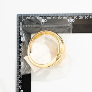 Gedetailleerd overzicht van gouden druppelarmband met liniaal voor maatreferentie