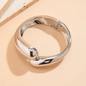 Detail van glanzende zilveren waterdruppelarmband met zichtbaar veerscharniermechanisme