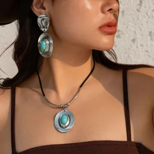 Detail view of ethnic silver-toned necklace and earrings set with turquoise on model