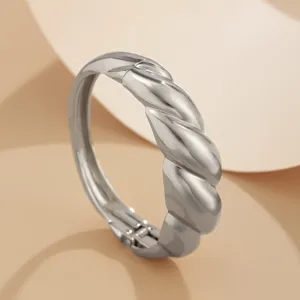 Close-up van de gepolijste zilverkleurige gedraaide croissantarmband met veerscharnier