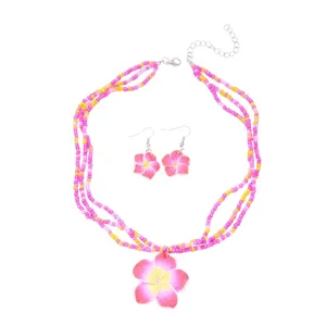 Detailansicht der Frangipani-Blütenanhänger und farbenfrohen Perlenstränge im Schmuckset