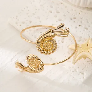 Vista dettagliata del design a conchiglia a spirale sul bracciale dorato regolabile