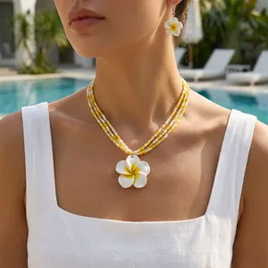 Detailansicht von Frangipani-Blüten-Samenperlen-Halskette und passenden Ohrringen
