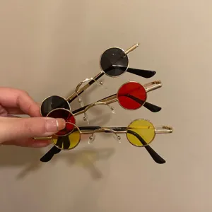 Vue détaillée de petites lunettes de soleil rondes rétro noir rouge et jaune