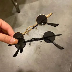 Détail de près de petites lunettes de soleil rondes steampunk avec montures noir et or