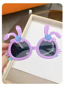 Detailed close-up of cute purple children's sunglasses with bunny ears and blue flower decor