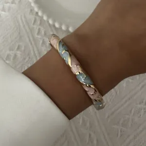 Detailed close-up of a retro enamel floral bangle featuring pink and blue flower patterns.
