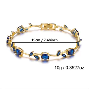 Detail view of gold-plated vine bracelet featuring blue gemstones and measurements