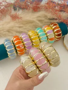 Bracciali elastici in resina marmorizzata color pastello con dettagli metallici