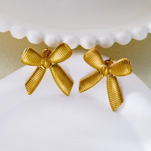 Detailed close-up of vintage golden bow earrings with a textured ribbed metal finish.