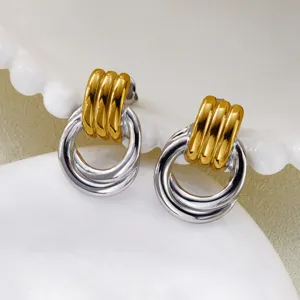 Detail of two-tone stainless steel ribbed hoop earrings in vintage gold and silver.