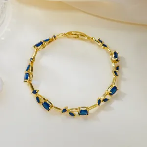 Detail view of a gold-plated leaf vine bracelet with elegant marquise blue gemstones