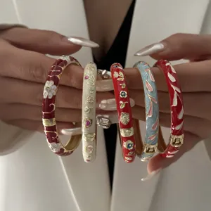 Elegant vintage Chinese style enamel floral bangles presented on hands in multiple colors