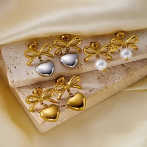 Vintage gold stainless steel bow earrings featuring heart and pearl dangle charms
