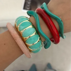 Pile di braccialetti in resina dai colori vivaci e bracciali elastici con tocchi dorati