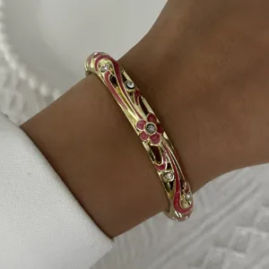 Vintage gold bangle with pink enamel floral patterns and sparkling crystal stones
