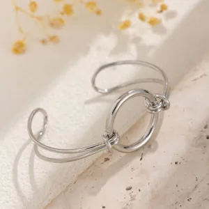 Dettaglio di un bracciale rigido argento a doppio strato con un nodo dal design minimal