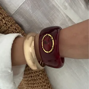 Bracelet jonc en résine rouge de style bohème avec un bracelet épais en or sur le poignet