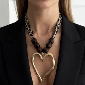 Detailed shot of leopard print scarf necklace with a golden lava heart pendant