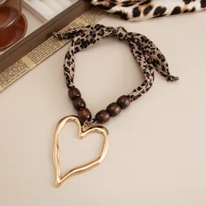 Close-up of vintage leopard print scarf necklace with golden molten lava heart pendant