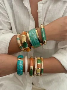 Bohemian style stackable enamel colorful bangles for vacation on white linen background