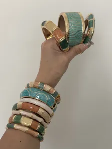 Detailed view of colorful bohemian enamel bangles with unique patterns and golden trim