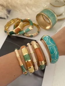 Detail of stacked Bohemian enamel bangles with colorful handmade dripping oil finish