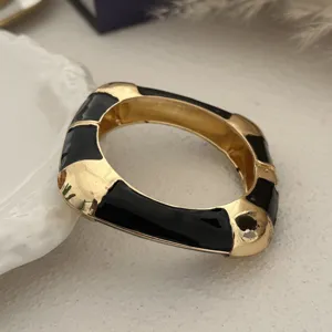 Close-up van een vintage zwart emaille en goudkleurige golvende armband