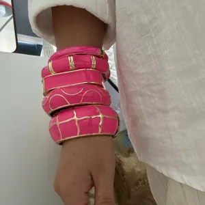 Vibrant fuchsia pink enamel bangles set with gold accents in a trendy dopamine style.