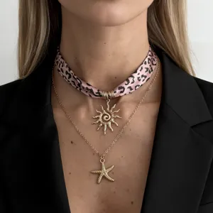 Detailed view of layered leopard print silk scarf choker and starfish pendant necklace.