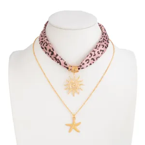 Vintage layered leopard print scarf necklace featuring golden sun and starfish pendants.