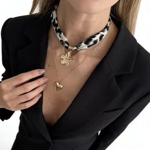 Detailed view of leopard print silk scarf choker featuring gold flower and heart charms