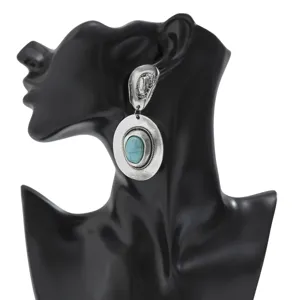 Close-up of vintage ethnic silver drop earring with turquoise stone on mannequin