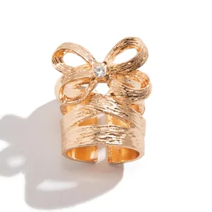 Eleganter texturierter goldener Schleifenring mit funkelndem Kristallakzent für Damen